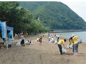 猪苗代湖の湖岸で人々が清掃活動をしている