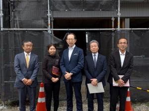 建設中の移住者(世帯用)住宅の前での記念撮影