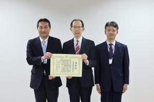 知事と受賞者２名が賞状を持ち並んでいる