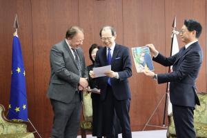 写真を見る知事と臨時代理大使