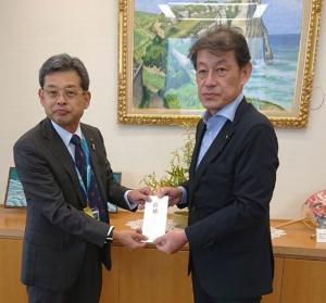 千葉県東京事務所長に目録を手渡す佐藤雅裕副議長の写真